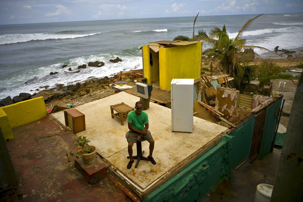 En esta foto del 5 de octubre de 2017, Roberto Figueroa Caballero aparece sentado en los restos de su casa en el barrio la Perla de San Juan, Puerto Rico. Foto: Ramon Espinosa / AP.