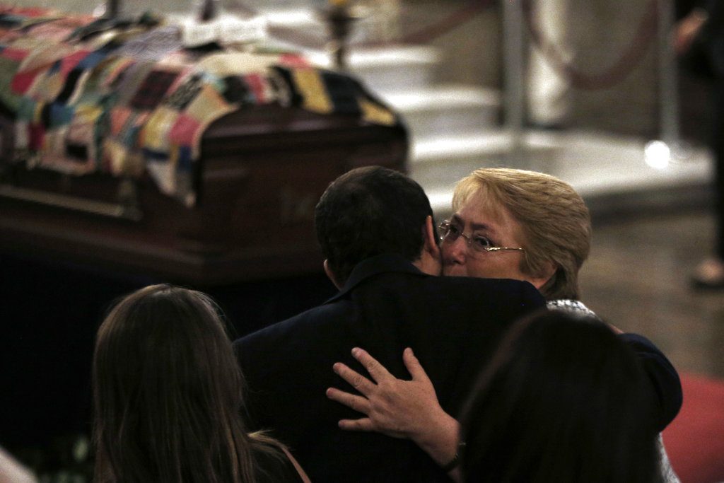 La presidenta de Chile Michelle Bachelet abraza a Cristóbal Ugarte, nieto del poeta Nicanor Parra, durante el servicio memorial de la Catedral de Santiago de Chile. Foto: Luis Hidalgo / AP.