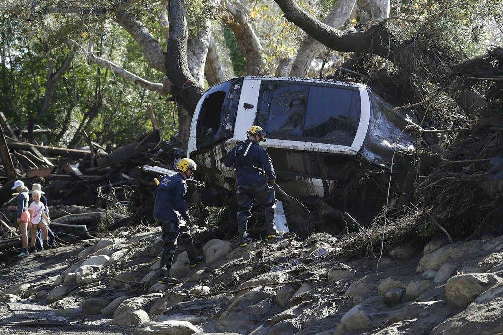 Miembros del Departamento de Bomberos del condado de Los Ángeles trabajan el miércoles 10 de enero de 2018 para sacar un automóvil que quedó atrapado en los escombros que dejaron las fuertes lluvias en la ciudad de Montecito, California. Foto: Marcio Jose Sanchez / AP.