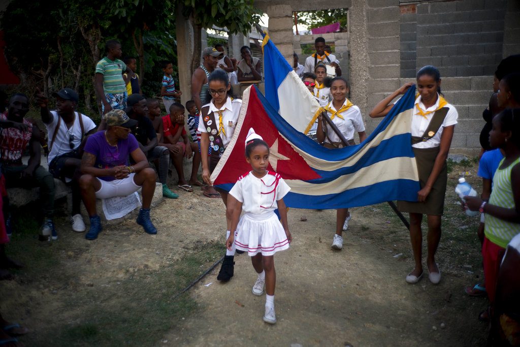 Niñas desfilan con una bandera de Cuba durante la ceremonia de apertura de una competición de lucha de nivel aficionado de una semana de duración organizada en enero por vecinos de Chicharrones, en Santiago de Cuba. Foto: Ramón Espinosa / AP.