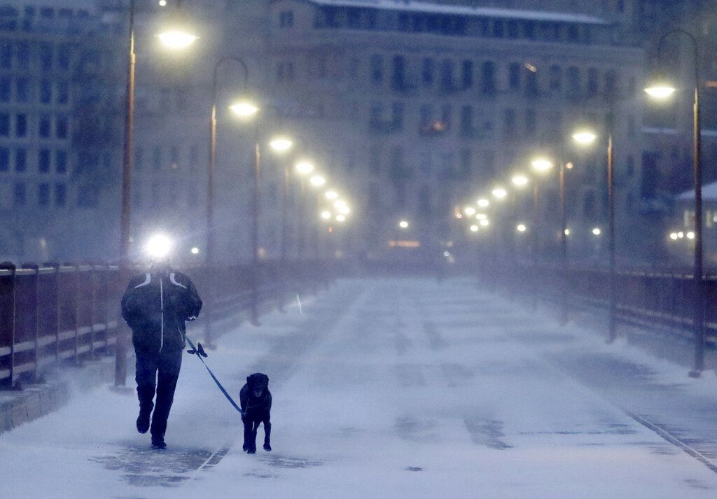 Un corredor y su perro soportan el frío extremo mientras cruzan el puente Stone Arch el jueves 24 de enero de 2019. (David Joles/Star Tribune vía AP)