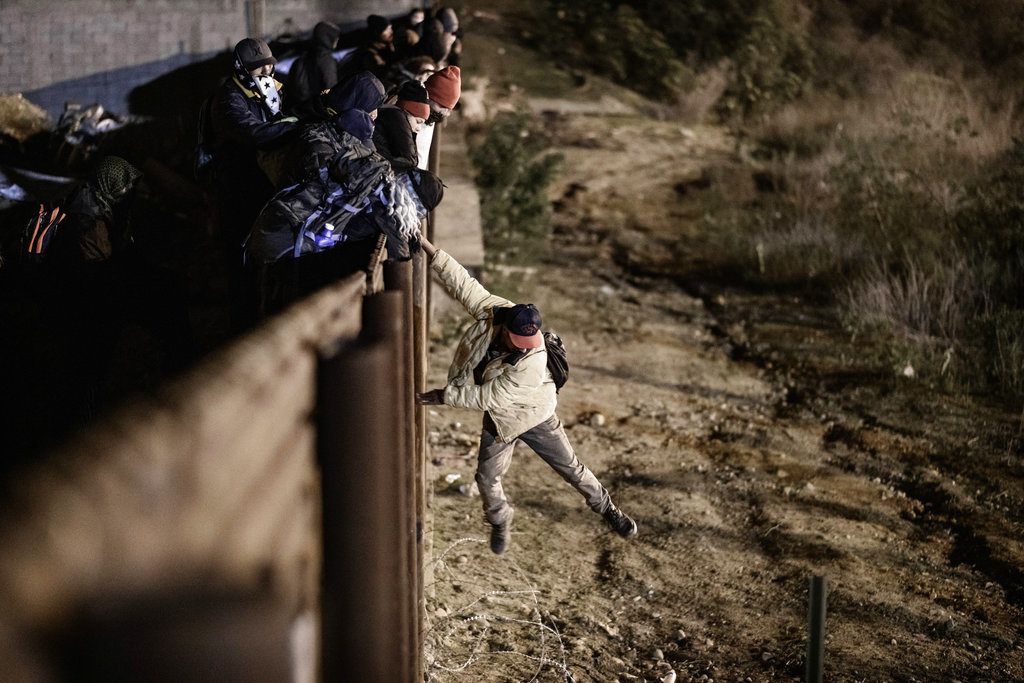 Un migrante salta la valla fronteriza entre Tijuana, México, y San Diego, California, el martes 1 de enero de 2019. Foto: Daniel Ochoa de Olza / AP.