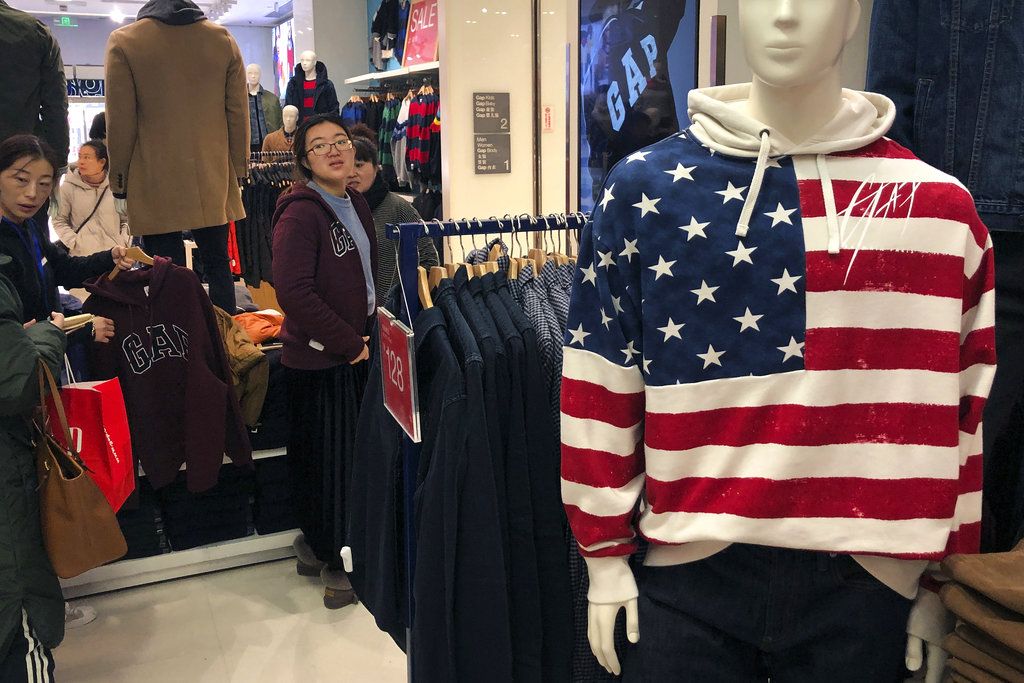 Una mujer se prueba una prenda en una tienda de la firma estadounidense GAP en Beijing, el 10 de enero de 2019. (AP Foto/Andy Wong)