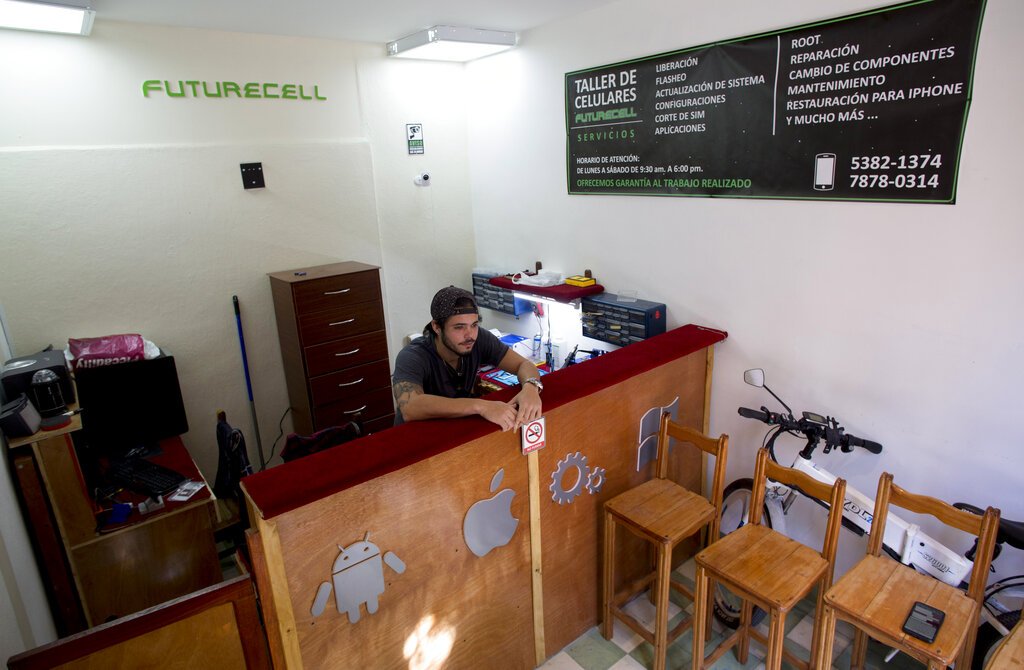Iván Rodriguez, de 25 años y dueño de Futurecell, un taller de reparación de teléfonos celulares, se encuentra en su tienda en La Habana, Cuba, el lunes 13 de enero de 2020. Foto: AP/Ismael Francisco