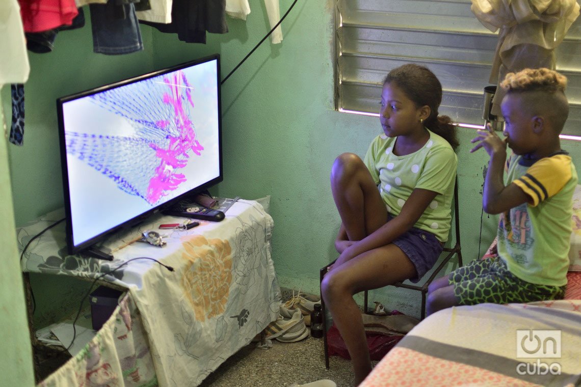 Los niños de Nelvis Águila ven la televisión en su nueva casa en el municipio Regla, reconstruida tras el paso por La Habana del tornado de enero de 2019. Foto: Otmaro Rodríguez.