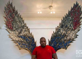 Cuban artist Michel Mirabal along with works of the personal exhibition that he is exhibiting in his gallery workshop, as part of the collateral activities of the 13th Havana Biennial. Photo: Otmaro Rodríguez.