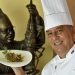 Chef Eddy Fernández, president of the island’s Federation of Culinary Associations and a tireless defender of Cuban cuisine. Behind, a statue of chef Gilberto Smith, founder of the Federation and one of the essential figures of culinary art on the island. Photo: Otmaro Rodríguez.