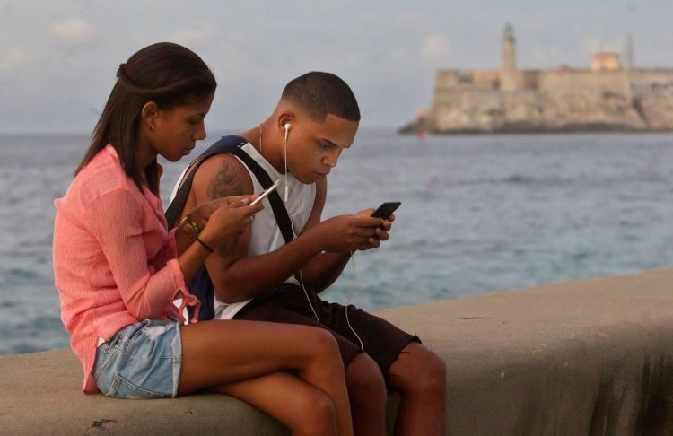 A young couple connects to the internet from the Malecón seawall, on December 27, 2018, in Havana. Photo: Yander Zamora / EFE.
