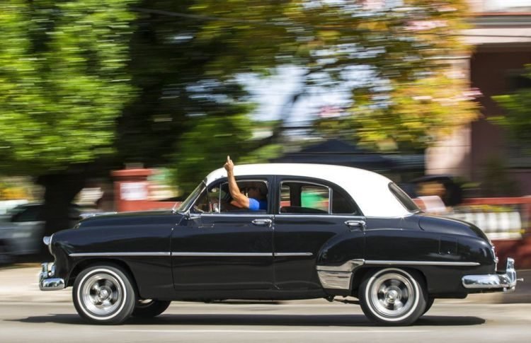 A taxi driver with a private license uses his hand to notify potential clients that he will turn right in Havana. Photo: Desmond Boylan / AP / Archive.