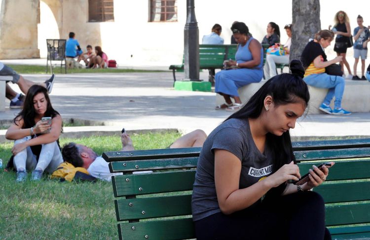 Several persons use their mobile phones in a park with Internet connection via public Wi-Fi, on December 27, 2018, in Havana. Photo: Ernesto Mastrascusa / EFE / Archive.