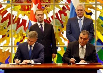 Cuban President Miguel Díaz-Canel Bermúdez (r-standing) and Russian Prime Minister Dmitry Medvedev (l-standing), observe the signing of a bilateral agreement between the two countries in Havana, on October 3, 2019. Photo: Ernesto Mastrascusa / POOL / EFE.
