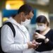 Passengers wearing masks as a precaution against the spread of the new coronavirus use their phones at the International Airport in Sao Paulo, Brazil, on Thursday, February 27, 2020. Photo: Andre Penner / AP.