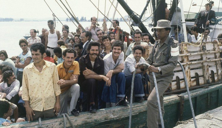 A Cuban soldier guards a ship in the port of Mariel on April 23, 1980, while people on board wait to sail to the United States. Photo: Jacque Langevin / AP.