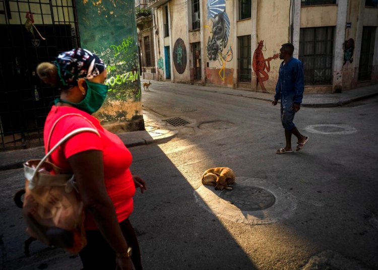 A woman walks with a mask as a precaution against the new coronavirus in Havana. Photo: AP/Ramon Espinosa.