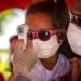 A girl wearing a mask to protect her from the new coronavirus has her temperature taken at a police checkpoint. This was at the entrance to the province of Havana, Cuba, on Monday, August 10, 2020.
