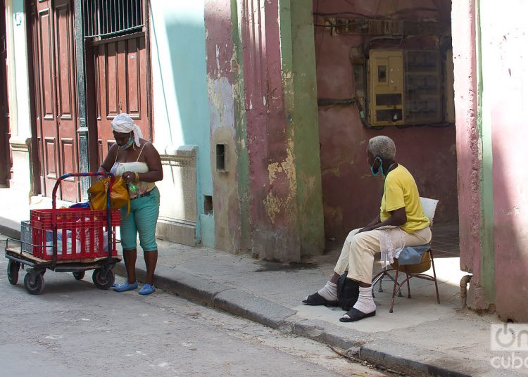 An elderly person waiting for the messenger to deliver her purchases. Photo: Otmaro Rodríguez.