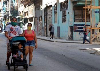 A couple walks their son in Havana. Photo: Ernesto Mastrascusa/EFE.