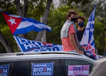 Some young people listen to the speech by former U.S. President Barack Obama, sitting on the roof of a car decorated with posters that say “Cubans with Biden Harris,” during a rally in support of the Democratic presidential candidate Joe Biden, on Campus Biscayne of Florida International University (FIU) in Miami, Florida. Photo: Giorgio Viera/EFE (Archive)