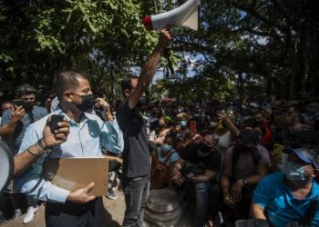 A Panamanian official gives information to hundreds of people waiting to resolve their situation in front of the Embassy of Panama, in Havana, on March 9, 2022. Photo: Yander Zamora/EFE.
