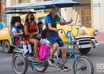 A mother takes her children to school in a pedicab, in Havana. Photo: Otmaro Rodríguez.