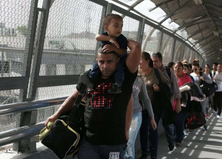 In this April 29, 2019 photo, Cuban migrants are escorted by Mexican immigration authorities in Ciudad Juarez, Mexico. (AP Photo/Christian Torres)