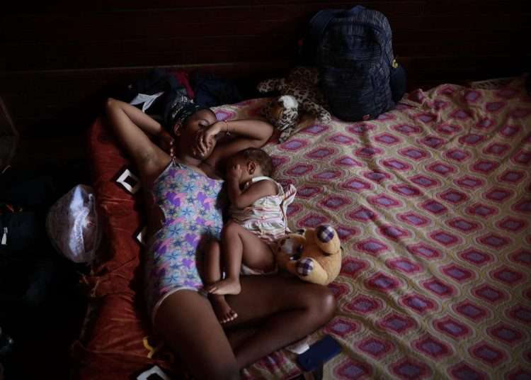 A Venezuelan migrant and her son rest in a temporary shelter after crossing the Darien jungle on their way to the United States, on May 11, 2023, in Los Planes de Gualaca, Panama. While thousands of migrants continue their journey to the United States in dozens of buses from a shelter in northern Panama, a few make the reverse route to return to their countries, fed up with continuous abuse. Photo: EFE/Bienvenido Velasco.