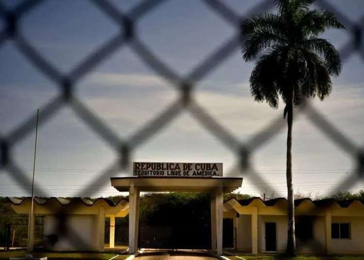 A building with the legend “República de Cuba. Territorio Libre de América,” behind a fence that marks the border with the United States Naval Base in Guantanamo Bay. Photo: Ramón Espinosa/AP.