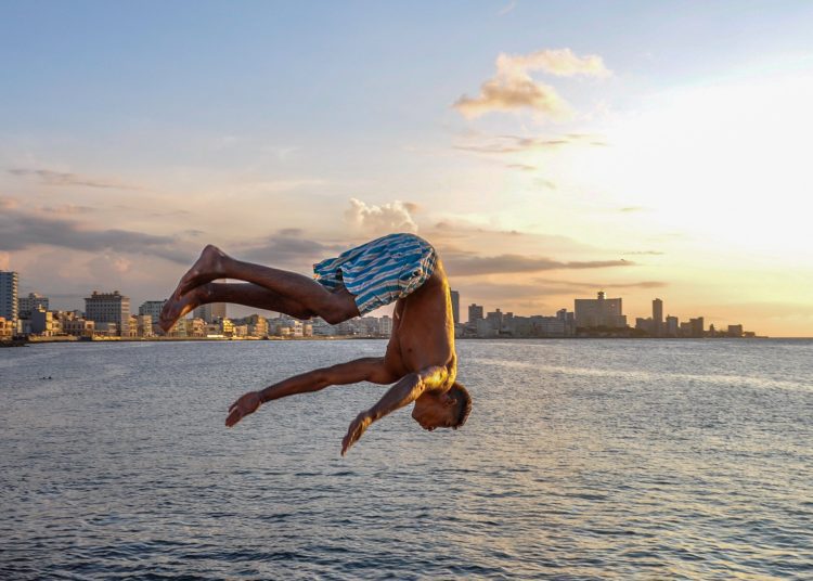 Young man jumps into the sea from the wall of Havana's Malecón