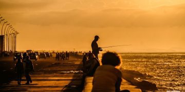 Cubans on the boardwalk in Havana. Economy in Cuba