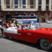People push a classic car with tourists, in Havana. Photo: Yander Zamora/EFE.