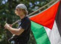 Santa Rosa Junior College student Julien Ducarroz carries a Palestinian flag after speaking during a rally and protest in support of Gaza on the Santa Rosa campus. Photo: Chad Surmick/The Press Democrat