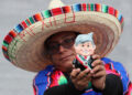 A person with a doll alluding to Mexico President Andrés Manuel López Obrador attends the ceremony for the 214th anniversary of the Cry of Dolores, on September 16, from the Zócalo esplanade in Mexico City. Photo: EFE/Mario Guzmán.