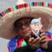 A person with a doll alluding to Mexico President Andrés Manuel López Obrador attends the ceremony for the 214th anniversary of the Cry of Dolores, on September 16, from the Zócalo esplanade in Mexico City. Photo: EFE/Mario Guzmán.