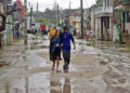 People walk along a street affected by Hurricane Melissa in Santiago de Cuba
