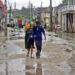 People walk along a street affected by Hurricane Melissa in Santiago de Cuba
