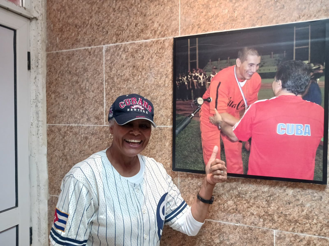 Maureen Taylor Hicks in front of a photograph of the great Cuban catcher Ariel Pestano, who participated in the meeting organized by the Cuba Foundation in Santa Clara. Photo: Courtesy of MTH.