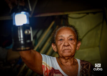 An elderly woman lights her way with a lantern during a power outage in Havana