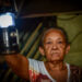 An elderly woman lights her way with a lantern during a power outage in Havana