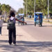 Cuba. A woman attempts to board an electric tricycle.