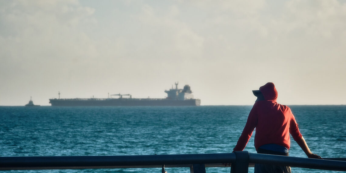 Man observes oil tanker in Cuba