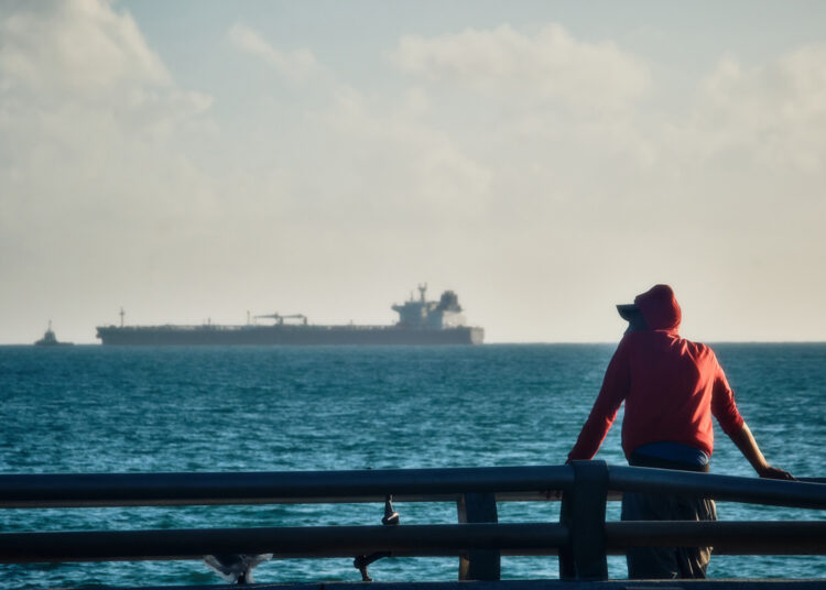 Man observes oil tanker in Cuba