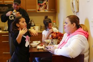 Enghie Melendez sentada junto a sus hijas y su marido, Fernando Moyet, en la cocina de su hotel en el barrio de Brooklyn, Nueva York. Foto: Frank Franklin II / AP.