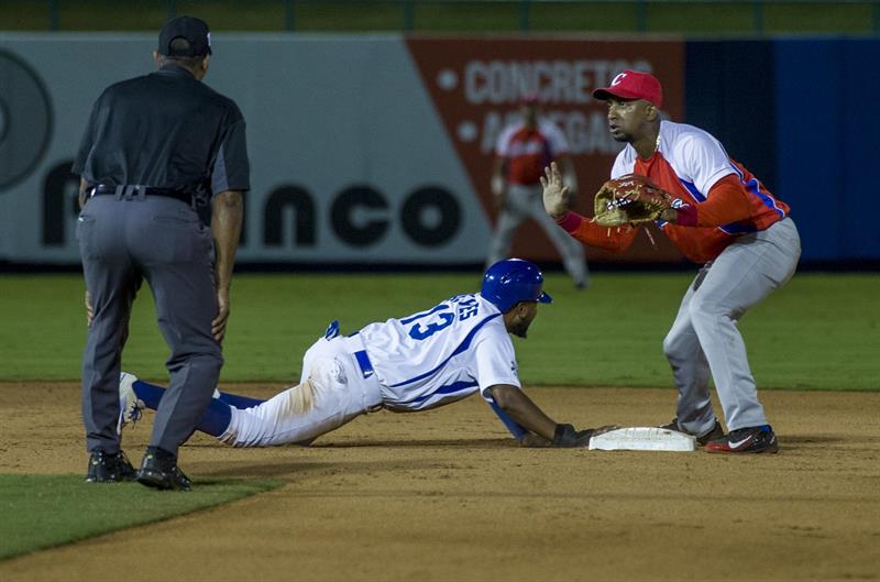 El nicaragüense Elmer Reyas (i), se barre en segunda base ante un jugador de la selección de Cuba en el estadio Dennis Martínez en Managua. Foto: Jorge Torres / EFE.