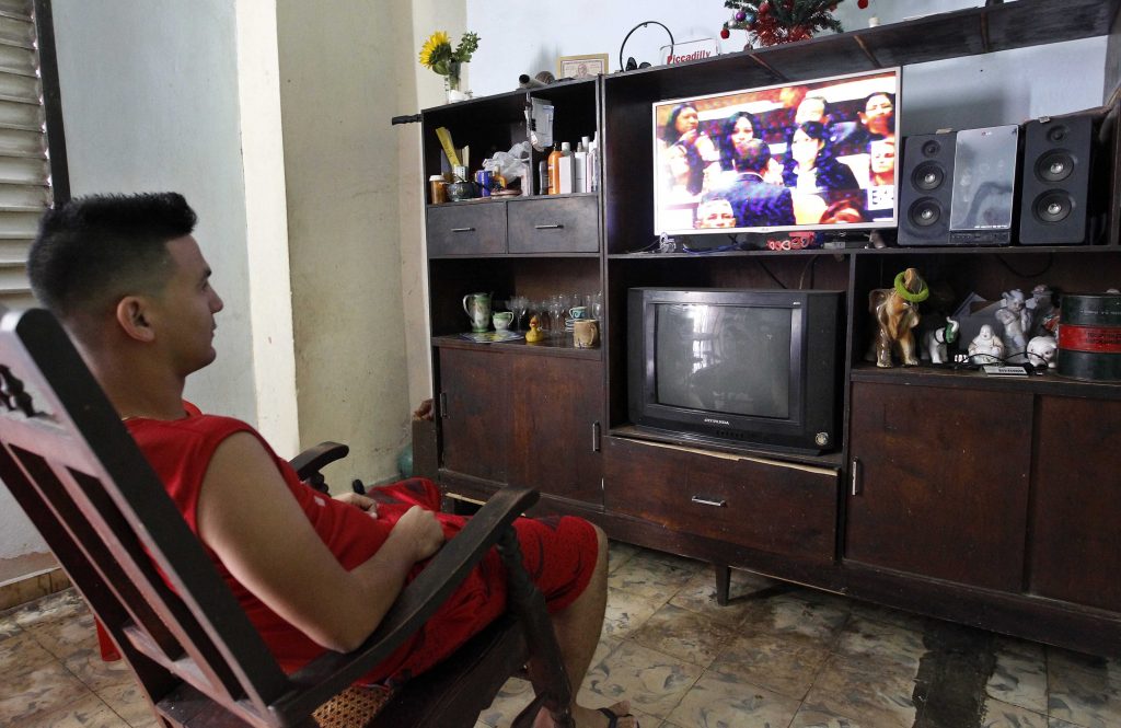 Un hombre ve desde su casa la programación especial de la Televisión Cubana donde se transmite en vivo la sesión constitutiva de la IX Legislatura de la Asamblea Nacional del Poder Popular. Foto: Ernesto Mastrascusa / EFE.