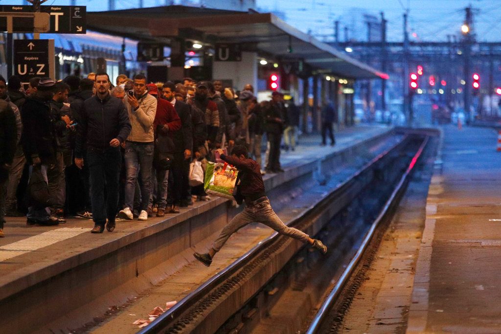 Un pasajero cruza las vías del tren de un salto durante la hora punta en la estación Gare de Lyon de París, durante una jornada de huelga masiva convocada por un sindicato, el 3 de abril. Foto: Francois Mori / AP.