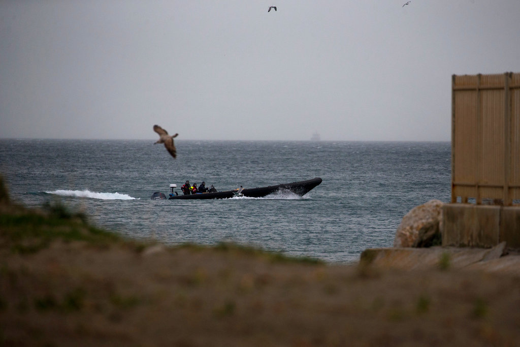 Una lancha rápida cargada con cajas en las que supuestamente habría droga navega junto a la costa de la Línea de la Concepción, en Cádiz. (AP Foto/Emilio Morenatti)