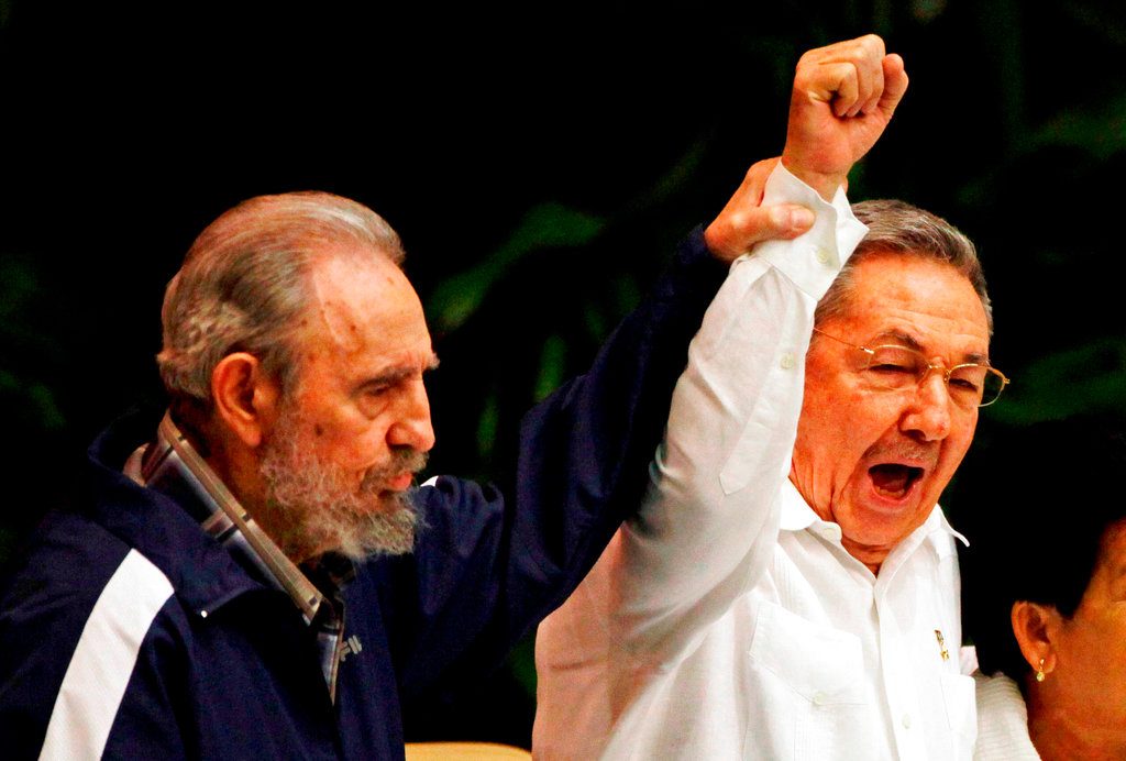 Fidel Castro levanta la mano de su hermano, el presidente de Cuba Raúl Castro, mientras cantan el himno de la internacional socialista durante el VI Congreso del Partido Comunista en La Habana, el 19 de abril de 2011. Foto: Javier Galeano / AP.