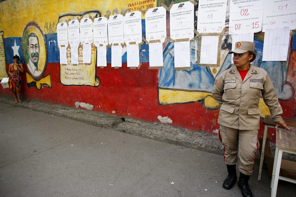 Miembro de la milicia bolivariana se detiene frente a las listas de votantes en un centro electoral durante los comicios presidenciales en Caracas, Venezuela, el domingo 20 de mayo de 2018. Foto: Ariana Cubillos / AP