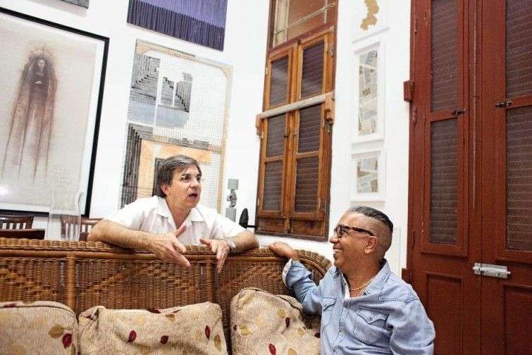 Alberto Magnan and Juanito Delgado at Delgado’s home in Havana which overlooks the Malecón, Havana’s seawall. Delgado says it is the inspiration for his exhibition which takes place at each Havana biennial. Delgado curates the exhibition with several public installations and performance art; Magnan this year discusses installing a hockey rink along the seafront. / Photo: Lisette Poole for Newsweek