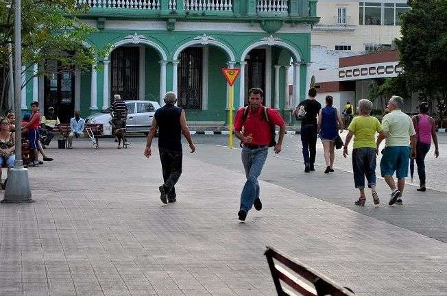 El hombre de mochila azul y camisa roja que corre delante de los carros de turismo. / Foto: Alexis Pérez Soria